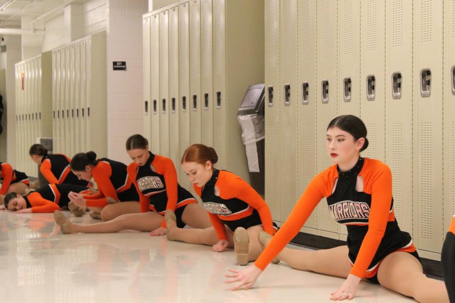 Avary Shrum stretches with the varsity dance team before their tournament performance. The dance team hosted the Fox Valley Conference championship at West Campus on January 15.