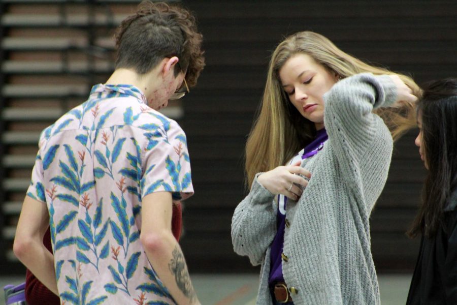 Seniors Julia Druml and Brandon Clough pin purple ribbons to their shirts, handed out by members of MAC to represent International Womens Day on March 6.