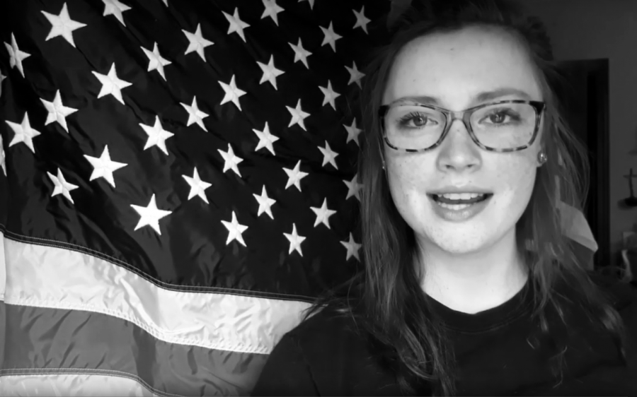 Jodi Cone stands in front of an American flag before reciting the Pledge of Allegiance during her video announcements on March 20.