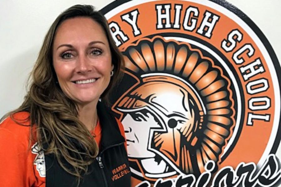 Hilary+Agnello+poses+with+the+McHenry+High+School+Warriors+logo.+Agnello+is+the+Varsity+volleyball+coach%2C+a+math+interventionist%2C+and+a+teacher+on+special+assignment.+
