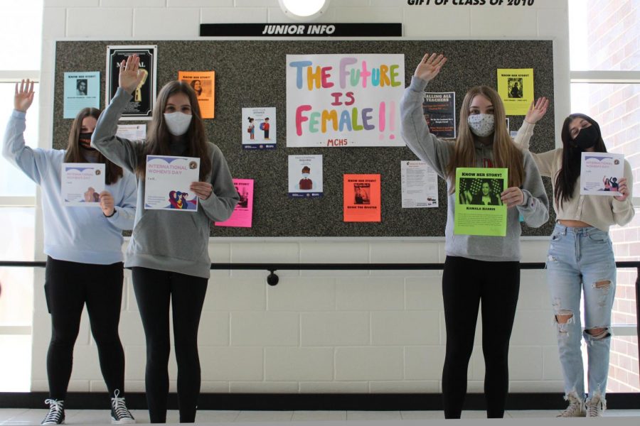 Students at West Campus post with a poster and signs celebrating International Womens Day on March 8.
