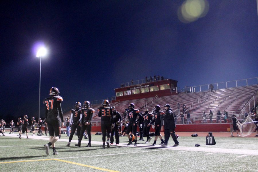 Varsity football players warm up before the first football game of a delayed season against Prairie Ridge on March 19 at Huntley High School.