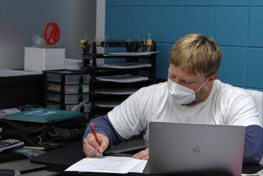 Science teacher Derek Poci grades papers in his classroom in the Center for Science, Technology, and Industry at the Upper Campus. A former East teacher, Poci is one of many teachers who switched campuses over the summer.