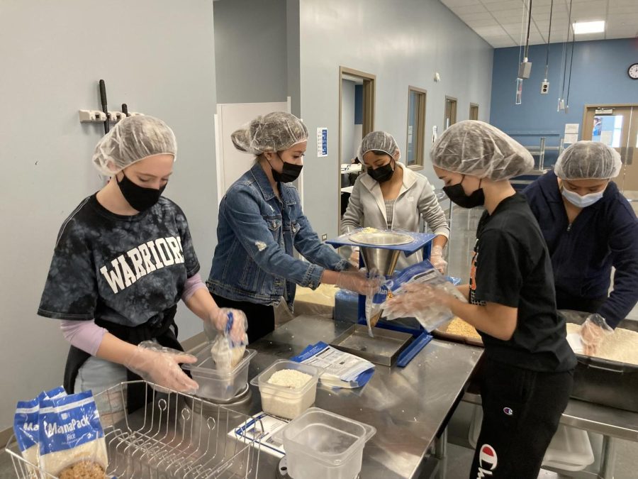 Members of MCHSs Key Club work on packing food for Feed My Starving Children Oct. 23. The group packed 105 boxes of food for food insecure people all around the world.