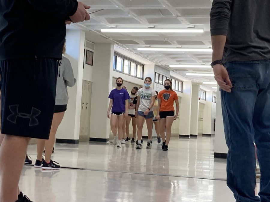 The girls track and field sprinters warm up on Jan. 25 in the hallways of the Upper Campus. Many spring teams are training indoors while they wait for their seasons to start — and snow to melt.