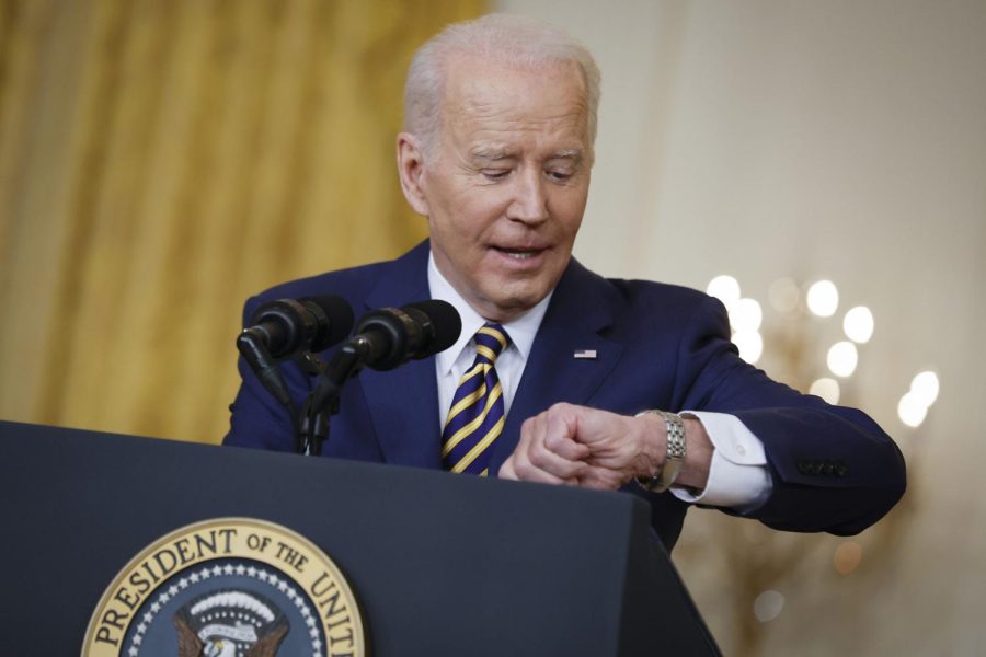 President Joe Biden checks his watch while answering questions during a news conference in the East Room of the White House on Wednesday, Jan. 19, 2022, in Washington, D.C. 
