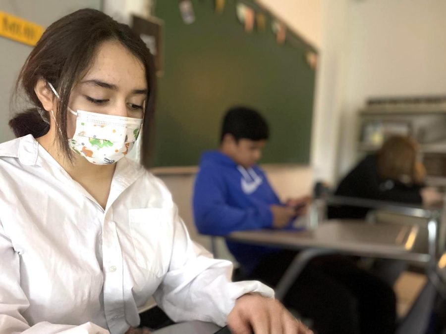 Freshman Jazmine Argueta dons her mask while working on an assignment during AIM on Feb. 7 in room 413 at the Freshmen Campus. Starting today, Students are not required to wear masks in the building for the first time since the spring of 2020.