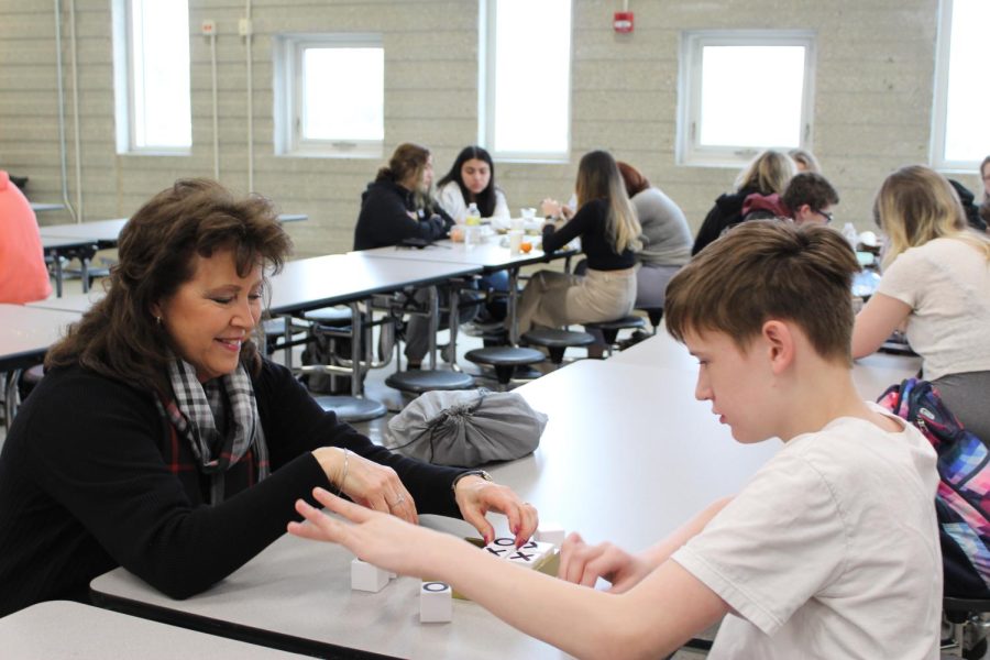 Steltzriede helps a student in her adjusted learning class play a game on March 23, 2022 in the cafeteria. 