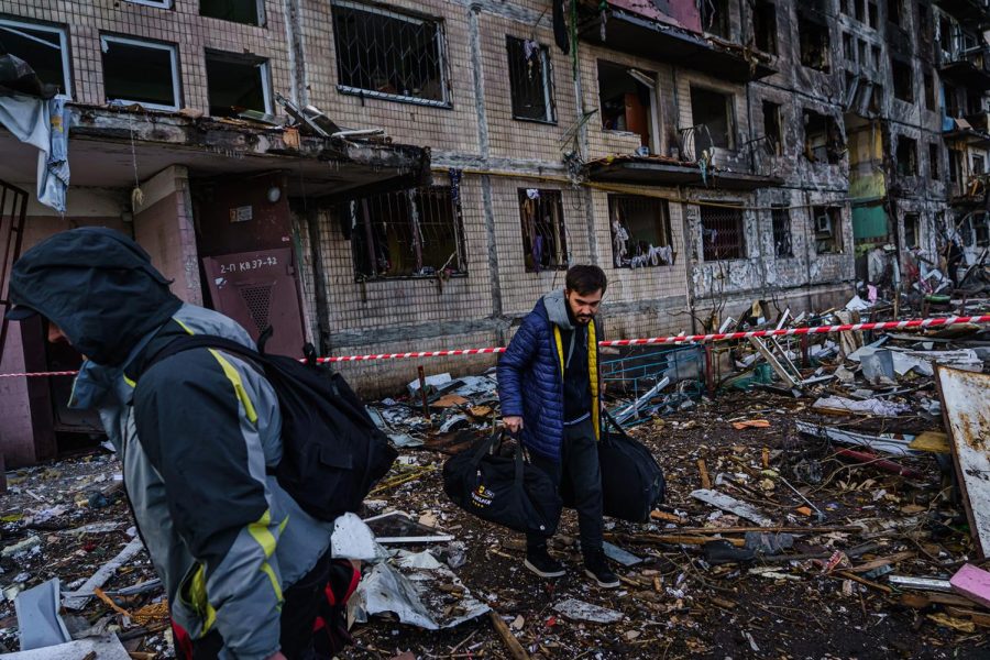 Residents carry bags out of an apartment building damaged by a Russian strike in suburban Kyiv, Ukraine on Monday, March 14, 2022. 