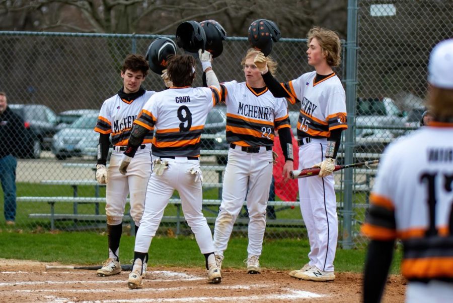 Varsity+baseball+players+celebrate+runs+earned+against+Jacobs+on+April+14+at+Peterson+Park.+The+team+fought+its+way+through+sectionals+and+super-sectionals+on+its+way+to+the+state+championship+for+the+first+time+in+school+history.