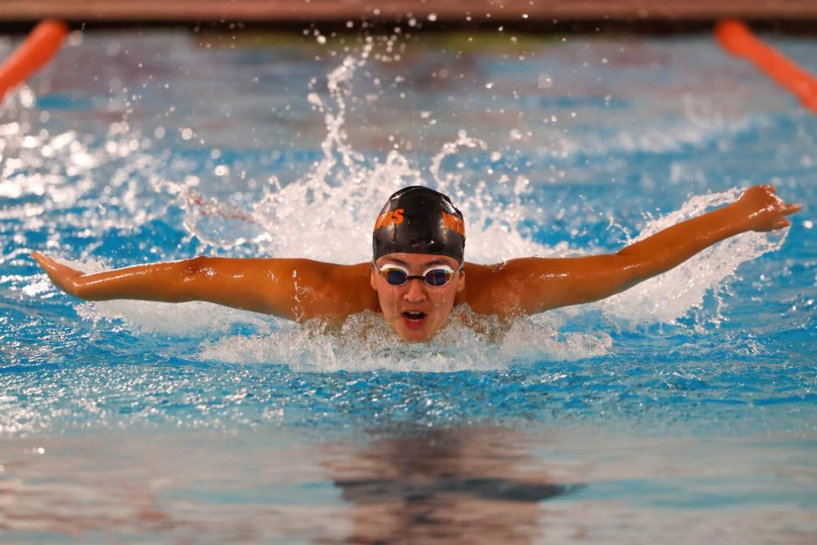 Andrea Avila flies through the pool during a girl swimming meet against Woodstock North on Sep. 7 in the Upper Campus pool. The Warriors won the meet 125-39.