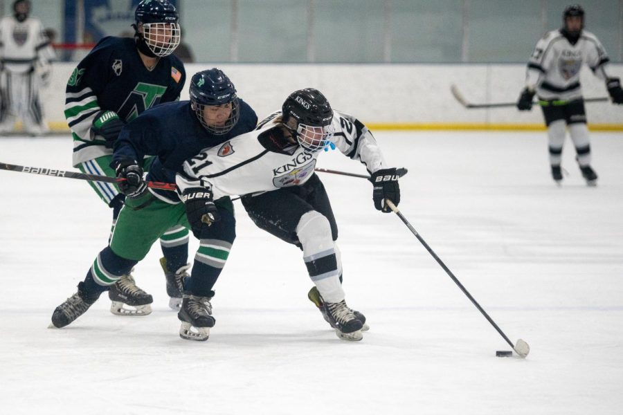 MCHS sophomore Brady Anderson pushes past players from New Trier High School during a Kings hockey match. Though the Kings arent an official MCHS athletic team, many students from MCHS play for the team.