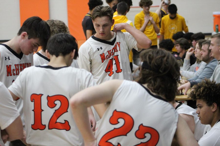 The JV boys basketball team meets in a time out during a game against Jacobs in the Upper Campus main gym on Friday.