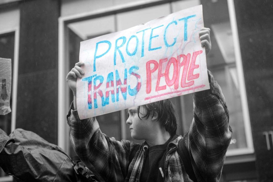 A person holds a sign reading Protect Trans People as LGBTQ activists protest on March 17, 2023, in front of the US Consulate in Montreal, Canada, calling for transgender and non-binary people be admitted into Canada. - According to police services, some 200 people gathered in the rain to show support for the trans community in the United States. 