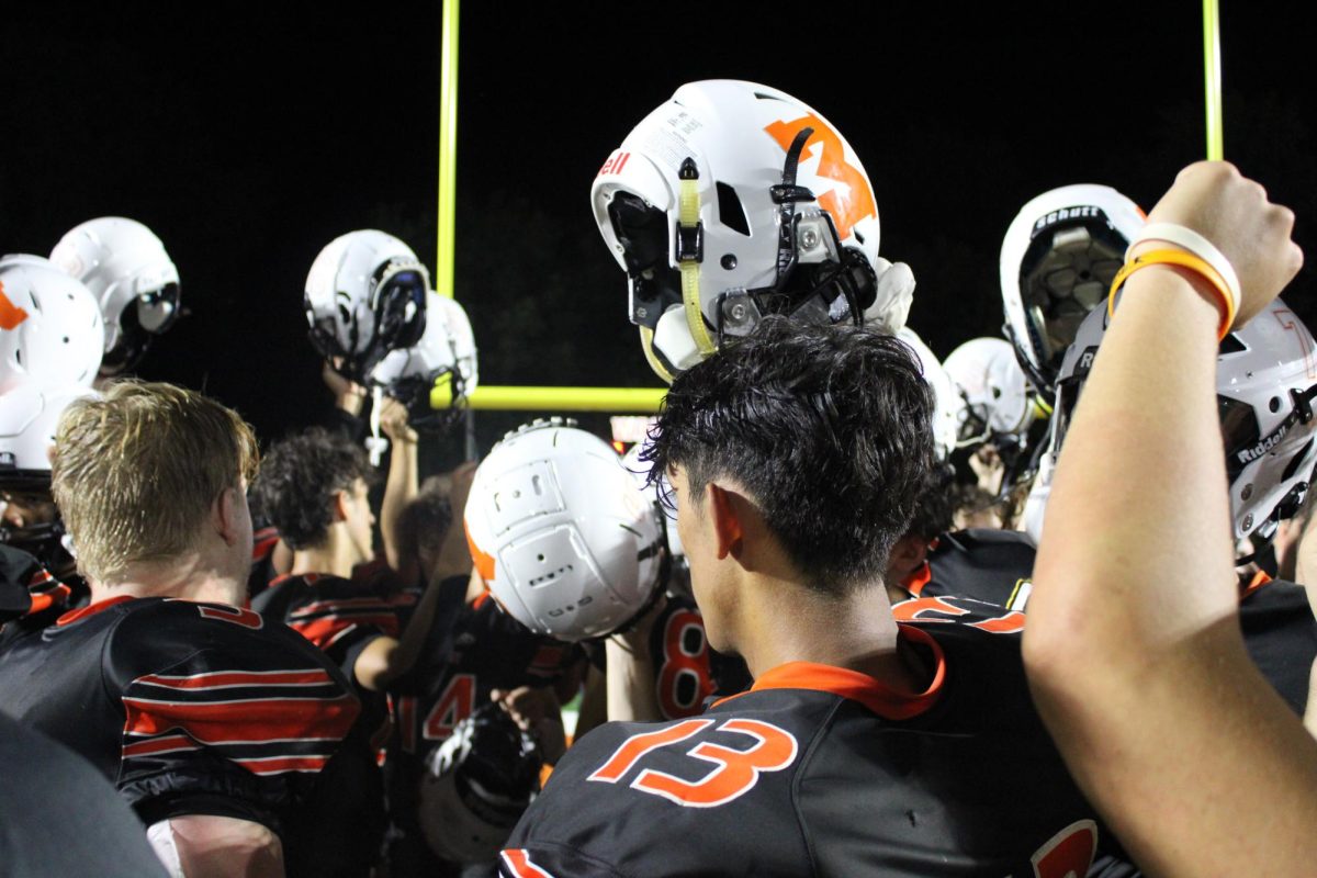 The football team meets in a hundle to end the game during the varsity football game against Huntley on Sept. 1 at McCracken Field.