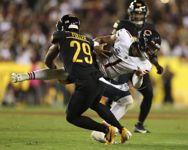 Chicago Bears quarterback Justin Fields (1) is hit by Washington Commanders cornerback Kendall Fuller (29) in the third quarter at FedEx Field on Oct. 5, 2023, in Landover, Maryland. 