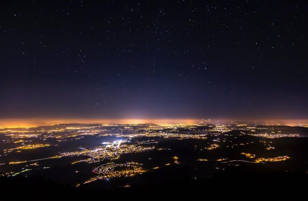 Not all stars are visible above populated areas because of light pollution. Far above the surface away from the light, cities like Rosinli, Switzerland see stars in the night sky.