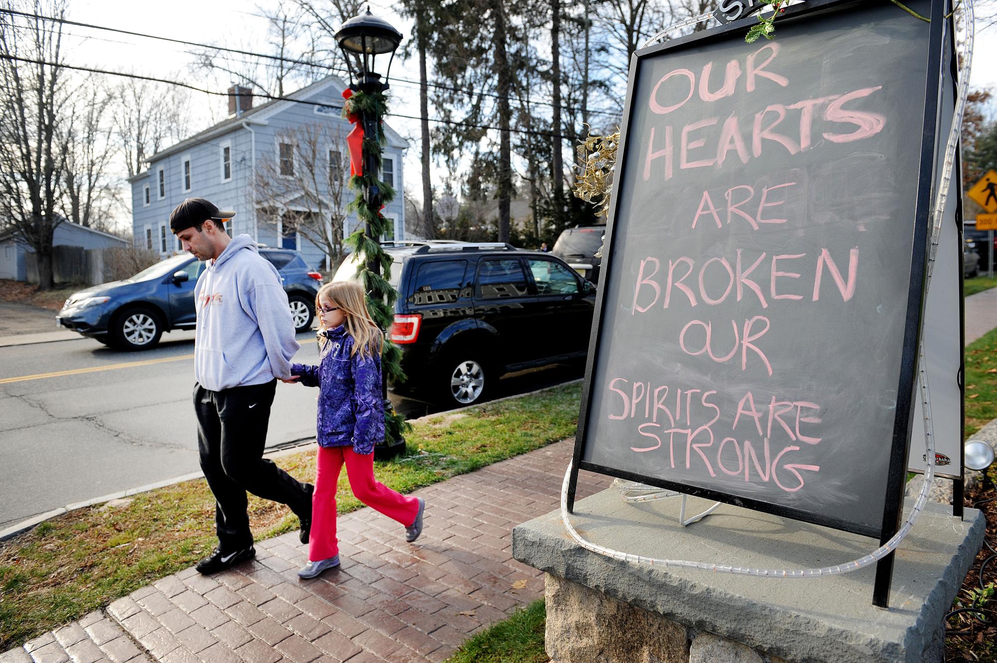 A sign speaks to the grief felt by residents from Newtown, Connecticut, on Saturday, December 15, 2012, a day after a shooting at Sandy Hook Elementary School where 26 people died.