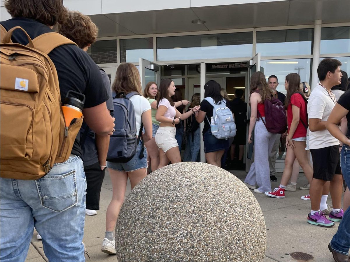 Students walk into the Upper Campus Wednesday, the first day of school, while Warrior activities welcome them back.