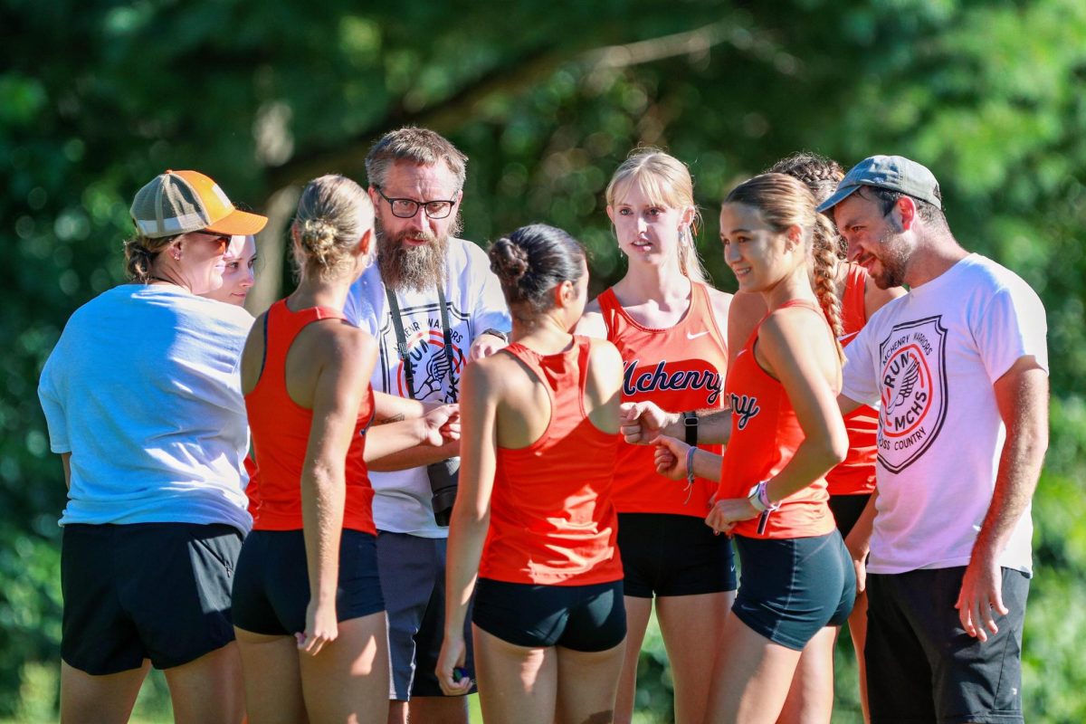 The varsity girls cross country team comes together to cheer each other on before a meet at McHenry Township Park on Aug. 31.