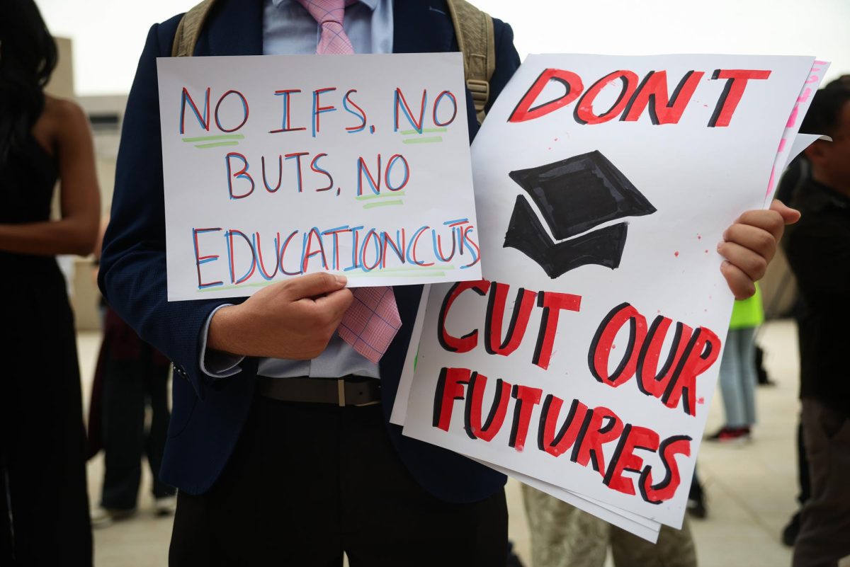 George Mason University student, Illia Sheikholeslami holds signs during the "Hands Off Our Schools" rally in front of the U.S. Department of Education on April 04, 2025 in Washington, DC. Students from Georgetown University, Howard University, American University, George Washington University, George Mason University, and Temple University gathered to protest President Donald Trump dismantling of the U.S. Department of Education. 