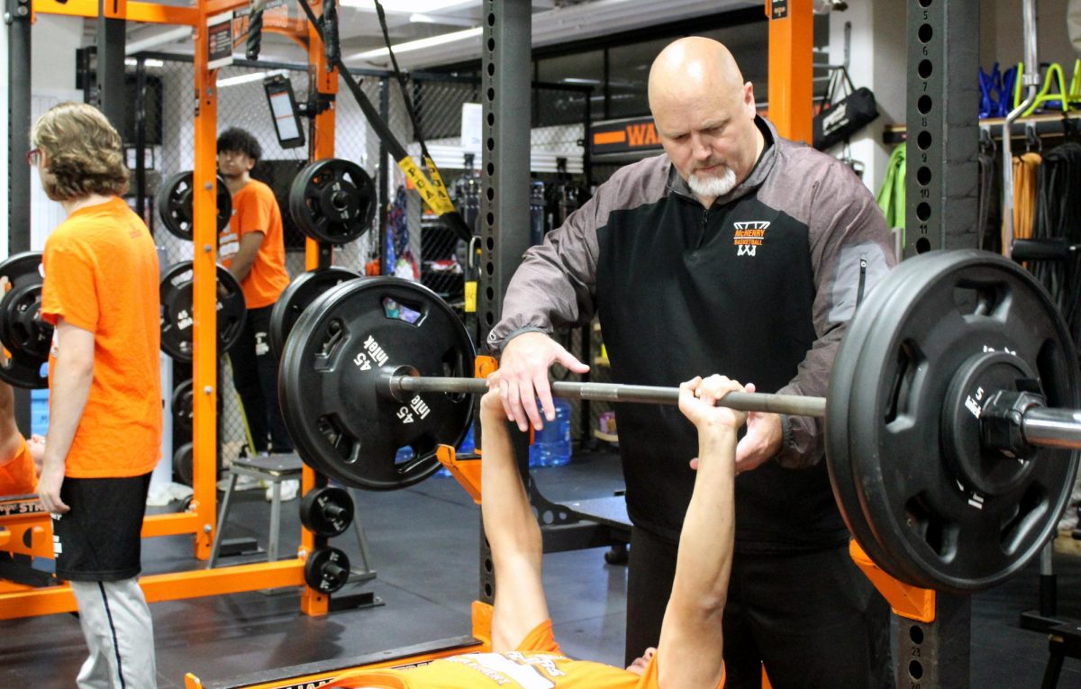 John Beerbower coaches one of his students in the Upper Campus weight room during his 4th period Strength and Conditioning class.