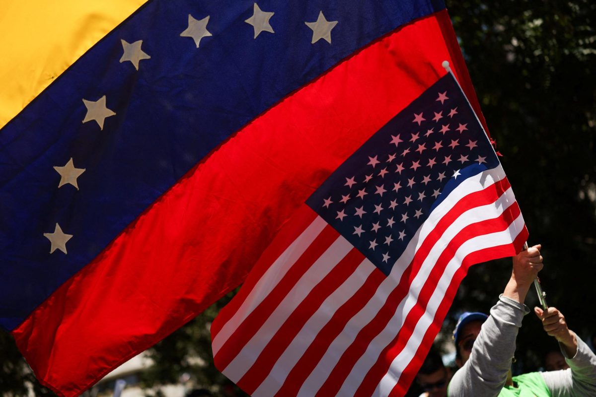 A person waves U.S. and Venezuela's flags as people celebrate following a U.S. strike on Venezuela where President Nicolas Maduro and his wife, Cilia Flores, were captured, in Santiago, Chile January 3, 2026.
