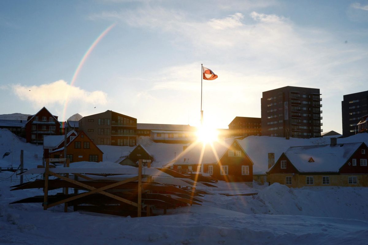 The sun rises behind Greenland's flag in Nuuk's old harbor, Greenland, February 5, 2025. REUTERS/Sarah Meyssonnier