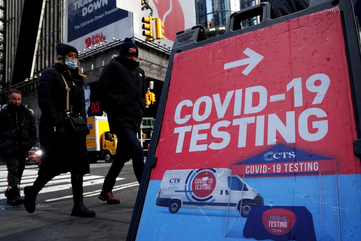 People walk past a COVID-19 testing sign during the coronavirus disease (COVID-19) pandemic in the Manhattan borough of New York City, New York, U.S., January 20, 2022. REUTERS/Carlo Allegri